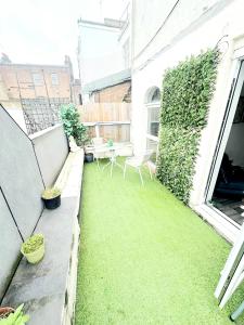 a small backyard with a green lawn on a building at Cozy Studio in Angel (Islington) in London