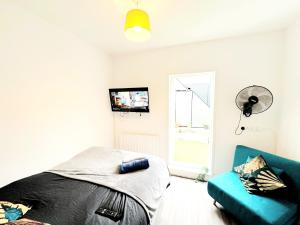 a bedroom with a bed and a couch and a tv at Cozy Studio in Angel (Islington) in London