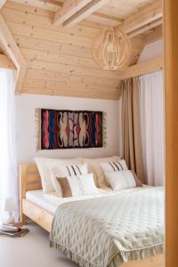 a bedroom with a large white bed with a chandelier at Domek Aziza in Kościelisko