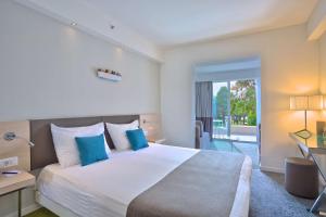 a bedroom with a large bed with blue pillows at Park Plaza Belvedere Medulin in Medulin