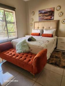 1 dormitorio con 1 cama grande y 1 sofá en Intsingizi bird lodge, en Pretoria