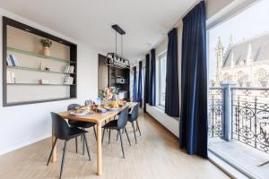 een eetkamer met een tafel en stoelen en een balkon bij Sweet Inn - Regence in Brussel