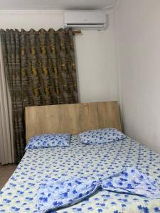a bedroom with a bed with a blue and white comforter at Ajsi Apartments in Durrës