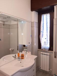 een badkamer met een witte wastafel en een spiegel bij Airport Casa Sofia in Fiumicino