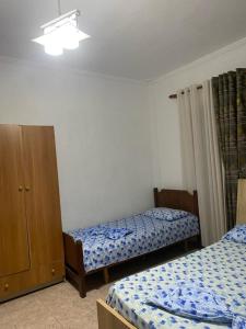 1 dormitorio con 2 camas y armario de madera en Ajsi Apartments, en Durrës