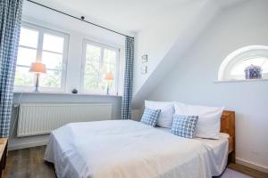 una camera da letto con un letto con cuscini blu e bianchi di Ferienhaus-Wattpieper a Munkmarsch