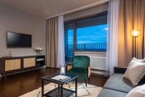 a living room with a couch and a chair and a television at The Tale Luxury Suites in Berlin