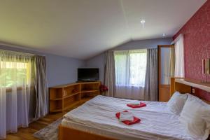 ein Schlafzimmer mit einem Bett mit roten Handtüchern darauf in der Unterkunft Вила “Рай” in Ribarica