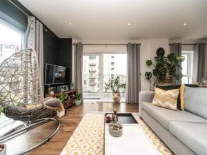 a living room with a couch and a chair at Pass the Keys Stunning and Stylish Flat Mins From Central London in London
