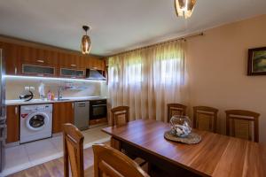 eine Küche mit einem Holztisch und einem Esszimmer in der Unterkunft Вила “Рай” in Ribarica