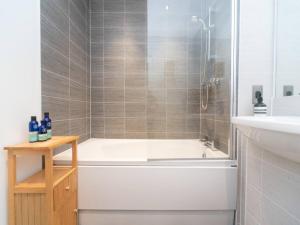 a bathroom with a bath tub and a sink at Pass the Keys Stunning and Stylish Flat Mins From Central London in London