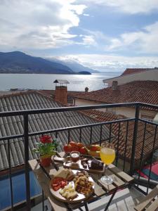 a table with a plate of food and a glass of orange juice at Bibi apartments in Ohrid