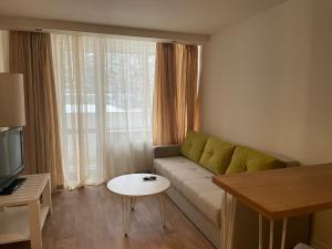 - un salon avec un canapé et une table dans l'établissement Festa Chamkoria Apartments, à Borovets