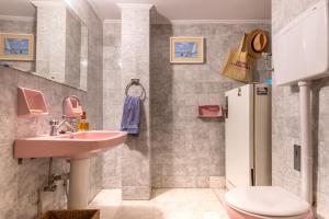 y baño con lavabo, aseo y nevera. en Chic 2BR Bright Penthouse with Open Wood Staircase, en Atenas