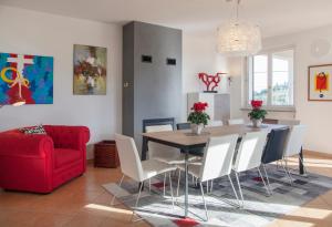 comedor con mesa y sofá rojo en Villa Bricco Astiani, en Montegrosso dʼAsti