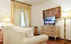 a living room with a white chair and a television at Emily Luxury Apartment in Verona