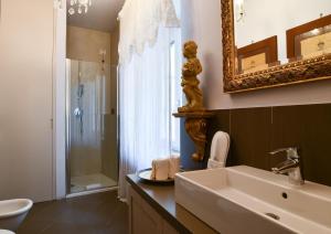La salle de bains est pourvue d'un lavabo, d'un miroir et d'une douche. dans l'établissement Emily Luxury Apartment, à Vérone