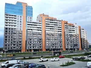 un estacionamiento con autos estacionados frente a edificios altos en Panorama Zamkowe 6, en Rzeszów