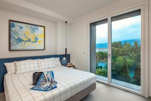 a bedroom with a bed and a large window at Grand Hotel Majestic in Verbania