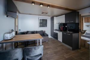 eine Küche und ein Wohnzimmer mit einem Tisch und einer Couch in der Unterkunft Sunset Premium Camping in Klenovica