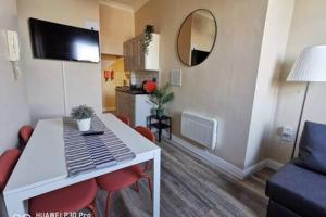 a living room with a white table and red chairs at Cosy Apartment near OConnell ST RELIABLE FAST WIFI in Dublin