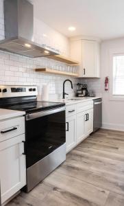 cocina con armarios blancos y fogones negros en Ocean Lofts in the Vibe #6 - 5 min walk to beach, en Virginia Beach 18 fotos más
