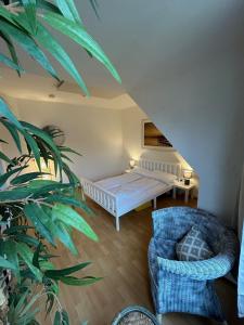 a bedroom with a bed and a chair and a plant at Beach Club Fehmarn 9249 in Fehmarn