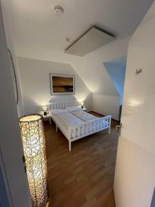 a bedroom with a white bed in a attic at Beach Club Fehmarn 9249 in Fehmarn