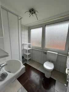 a bathroom with a white toilet and a sink at Beach Club Fehmarn 9249 in Fehmarn