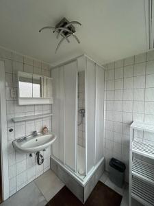 a white bathroom with a sink and a ceiling fan at Beach Club Fehmarn 9249 in Fehmarn