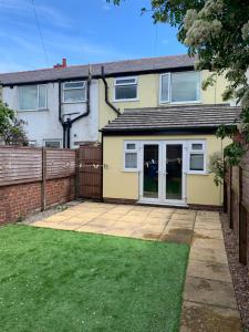 a house with a patio and a fence at Beautiful house Perfect Location Lytham St Annes in Saint Annes on the Sea