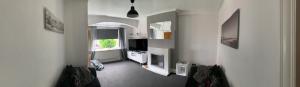 ein Wohnzimmer mit weißen Wänden und einem TV in der Unterkunft Beautiful house Perfect Location Lytham St Annes in Saint Annes on the Sea