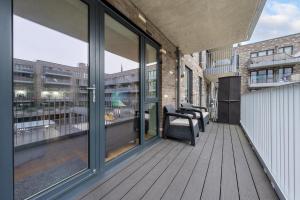 een balkon met glazen schuifdeuren in een gebouw bij Very Modern 17min London Paddington, 8min legoland in Slough