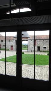 a view of a building from an open window at Ferme de la Porte Rouge in Andenne