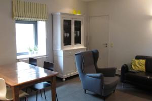 a living room with a wooden table and chairs at Ferme de la Porte Rouge in Andenne