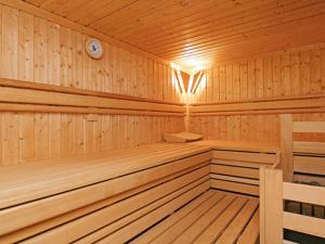 a wooden cabin with a sauna with a clock at Prahl Hüs 4 von Appartements & Mehr in Kampen