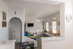 a living room with a couch and a tv at Villa Marie-Iphigenie in Antiparos