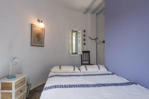 a white bedroom with a bed and a table at Villa Marie-Iphigenie in Antiparos