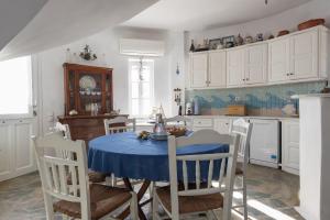 a kitchen with a table with a blue table cloth at Villa Marie-Iphigenie in Antiparos