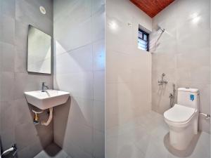 two images of a bathroom with a toilet and a sink at Baga Beach Walk in Baga