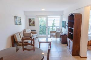 a living room with a table and a room with a balcony at Departamento Vista Huapi in San Carlos de Bariloche