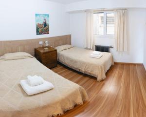 sypialnia z 2 łóżkami i drewnianą podłogą w obiekcie Departamento Vista Huapi w mieście Bariloche