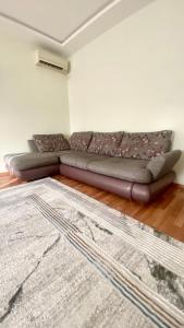 um sofá numa sala de estar com um tapete em 2х комнатная квартира на Айтиева em Taraz