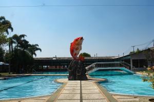 a statue of a fish on a fountain next to a pool at Grand Nirwana Resort Lembang in Tangkubanperahu