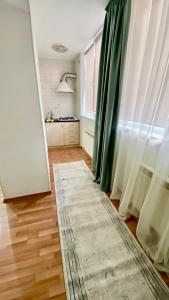 a living room with green curtains and a rug at 2х комнатная квартира на Айтиева in Taraz