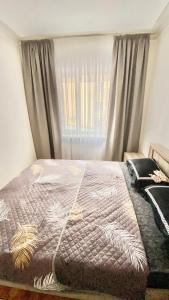 een slaapkamer met een bed en een raam met gordijnen bij 2х комнатная квартира на Айтиева in Taraz