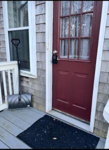 a red door on the side of a house at Charming Cottage Historic Falmouth Cape Cod Near Beach and Downtown 2BR 1Bath Deck in Falmouth