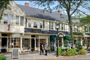 a group of people walking in front of a building at Charming Cottage Historic Falmouth Cape Cod Near Beach and Downtown 2BR 1Bath Deck in Falmouth