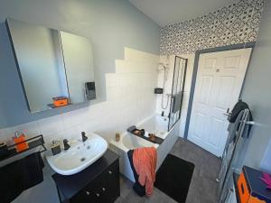 a bathroom with a sink and a white door at Arena House - Sleeps 6 in Sheffield