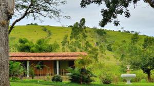 UbaíraTEHA Pousada的绿色山丘前的房屋
